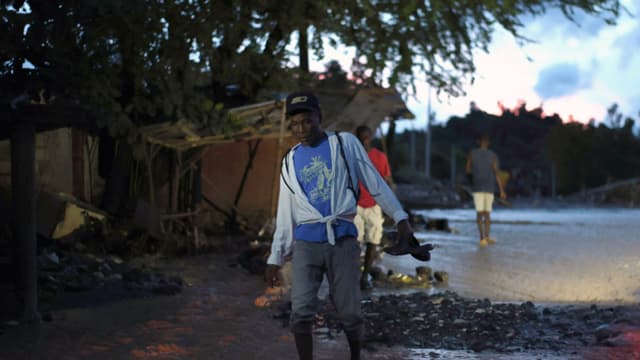 Una persona fue captada este miércoles, 29 de octubre, al caminar sobre el lodo tras la creciente del río La Digue, provocada tras el paso del huracán Melissa, en Petit Goave, Haití. (EFE/Mentor David Lorens)