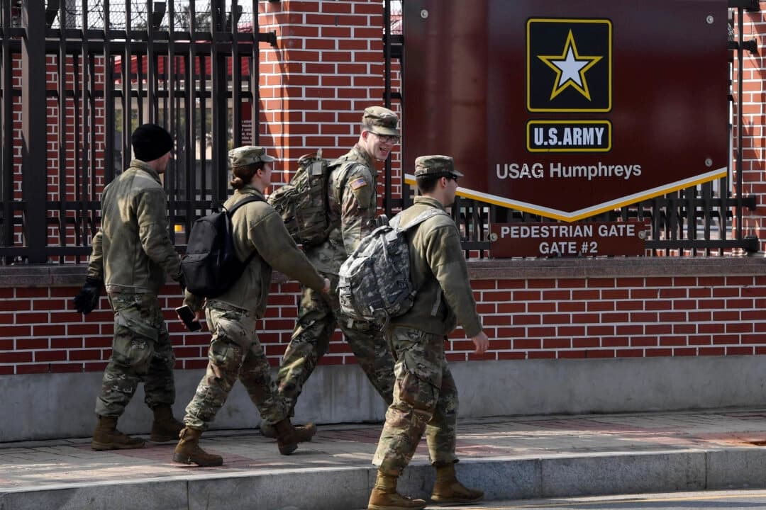 Soldados estadounidenses pasan frente a una puerta del Campamento Humphreys de EE. UU. en Pyeongtaek, Corea del Sur, el 21 de febrero de 2019. (Jung Yeon-je/AFP vía Getty Images)