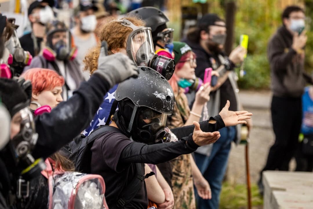 Manifestantes se reúnen frente a las oficinas del Servicio de Inmigración y Control de Aduanas en Portland, Oregón, el 4 de octubre de 2025. (John Fredricks/The Epoch Times)