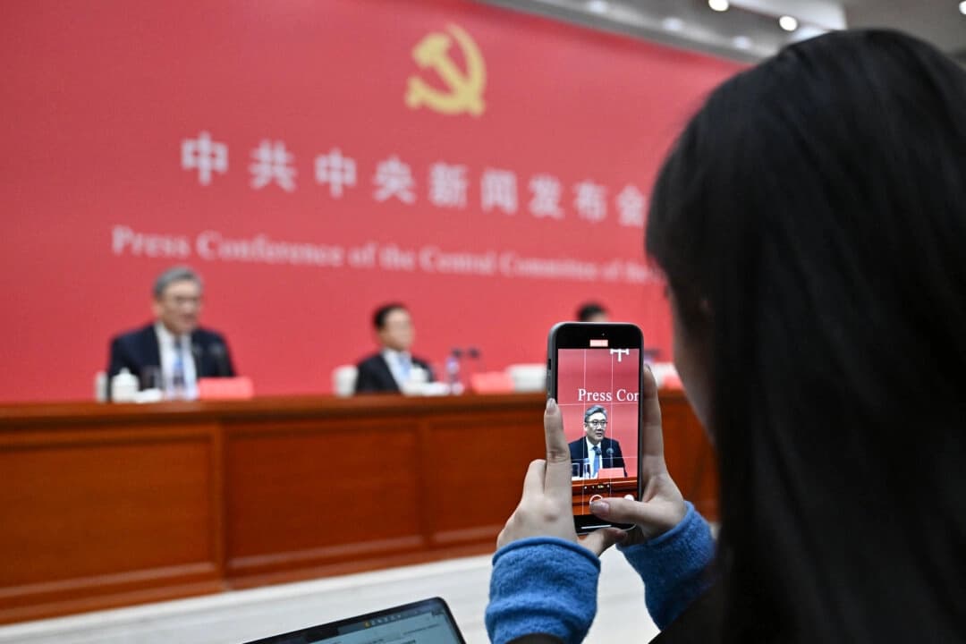 Una periodista graba un vídeo del ministro de Comercio chino, Wang Wentao, mientras asiste a una rueda de prensa del Comité Central del Partido Comunista Chino en Beijing el 24 de octubre de 2025. (Pedro Pardo/AFP/Getty Images)