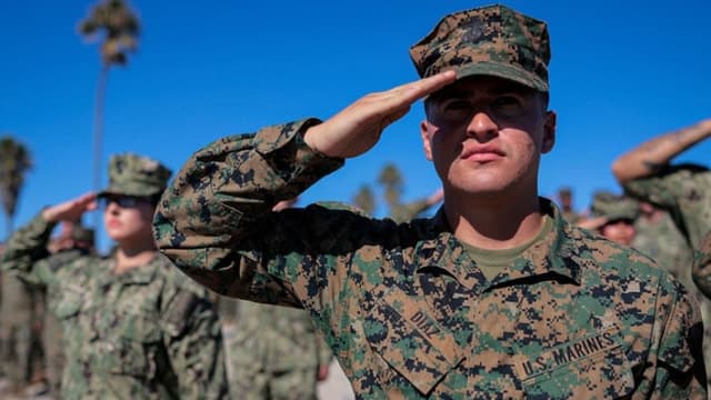 Marines y marineros estadounidenses saludan durante el himno nacional en la celebración del 250 aniversario del Cuerpo de Marines de los Estados Unidos en la base del Cuerpo de Marines Camp Pendleton el 18 de octubre de 2025 en Oceanside, California. (Mario Tama/Getty Images)