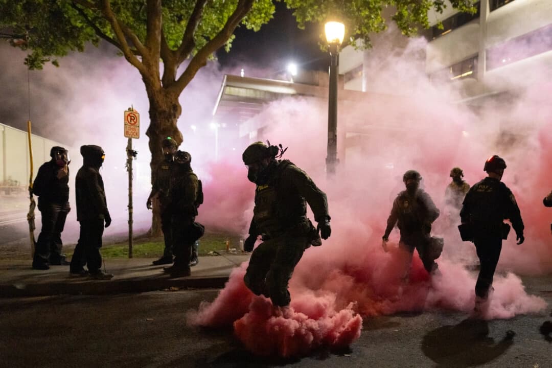 Agentes federales desplegaron granadas de humo para dispersar a manifestantes frente a las oficinas del Servicio de Inmigración y Control de Aduanas en Portland, Oregón, el 5 de octubre de 2025. (John Fredricks/The Epoch Times)