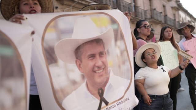 Personas sostienen carteles en una manifestación por el asesinato del alcalde de Uruapan Carlos Manzo este miércoles, en Morelia, México. (EFE/ Iván Villanueva)