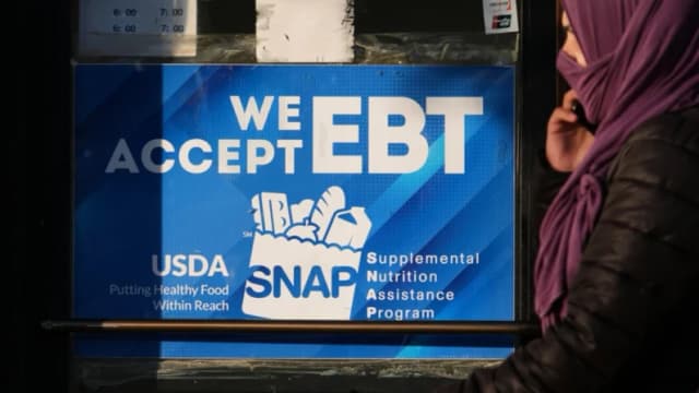 Un letrero informativo sobre el EBT de SNAP se muestra en una panadería mientras una mujer pasa en Chicago el 2 de noviembre de 2025. (Foto AP/Nam Y. Huh)