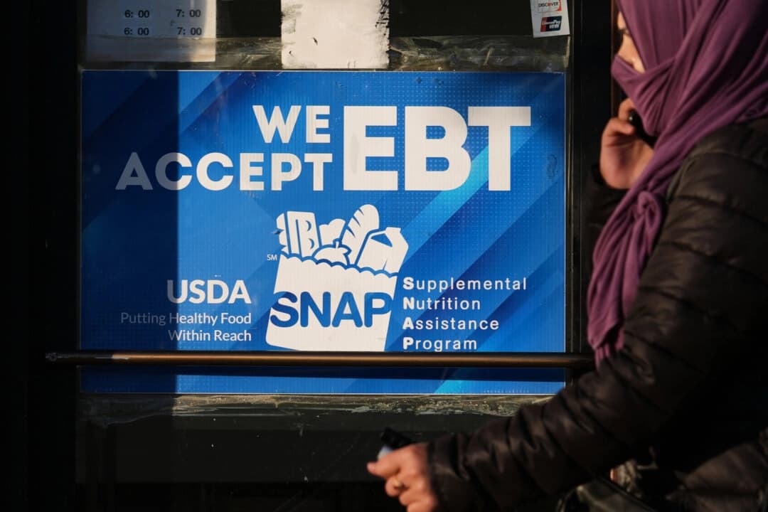Un letrero informativo sobre el EBT de SNAP se muestra en una panadería mientras una mujer pasa en Chicago el 2 de noviembre de 2025. (Foto AP/Nam Y. Huh)