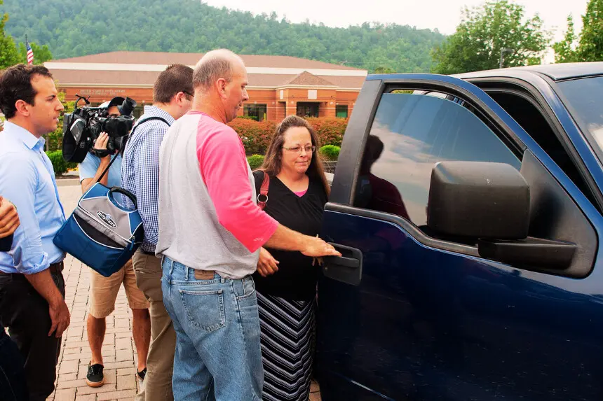 La ex secretaria del juzgado del condado de Rowan, Kim Davis, es escoltada hasta su vehículo en 2015, en Morehead, Kentucky. Davis, que es cristiana apostólica, se ha negado a emitir licencias de matrimonio a parejas del mismo sexo desafiando un fallo de la Corte Suprema citando objeciones religiosas. (Foto de Ty Wright/Getty Images).