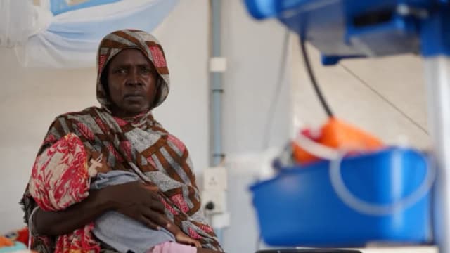 Una mujer sudanesa desplazada y herida que huyó de la violencia en Al-Fashir recibe tratamiento mientras lleva a su hijo en brazos en una clínica improvisada gestionada por Médicos Sin Fronteras (MSF), en medio de los continuos enfrentamientos entre las Fuerzas de Apoyo Rápido (RSF) paramilitares y el ejército sudanés, en Tawila, Darfur del Norte, Sudán, el 3 de noviembre de 2025. (REUTERS/Mohamed Jamal)