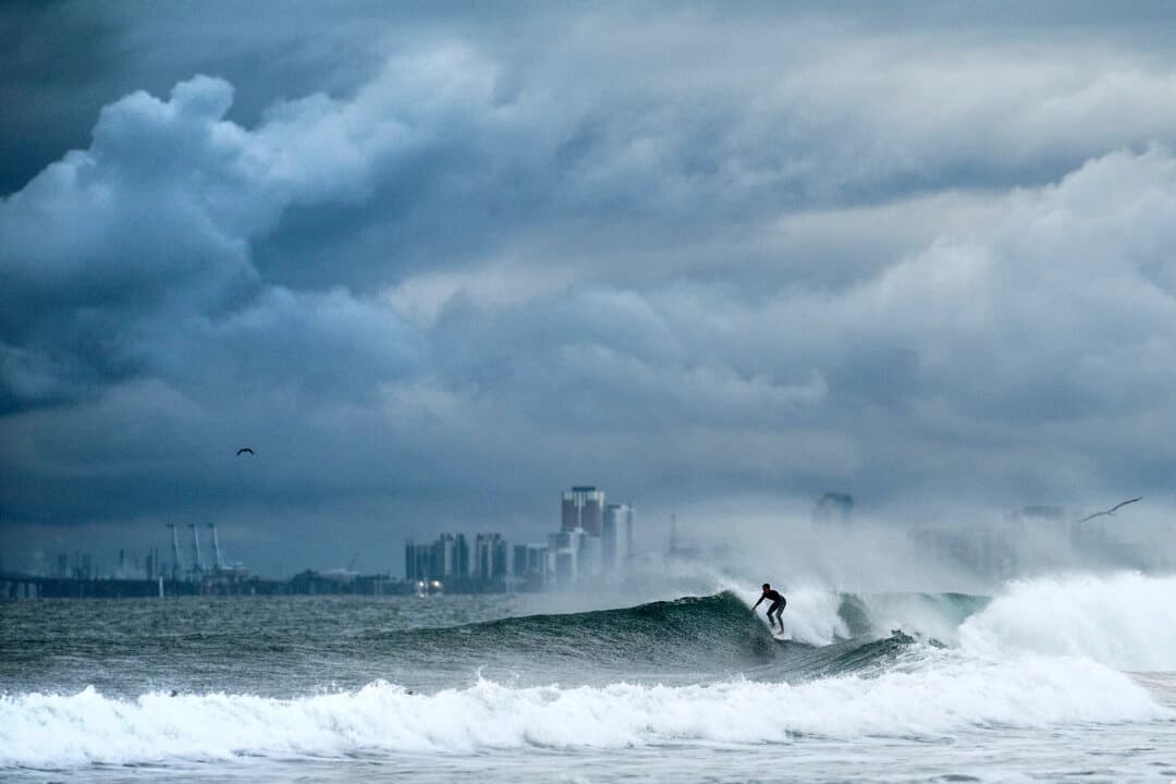 Un surfista cabalga una ola mientras las nubes se acumulan sobre la playa estatal de Bolsa Chica, en el condado de Orange, California, el 15 de noviembre de 2025. (Noah Berger/AP Photo)