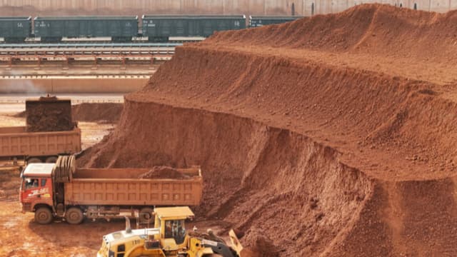 Maquinaria pesada manipulando mineral de bauxita en el puerto de Yantai, en la provincia de Shandong, al este de China, el 29 de octubre de 2025. (Foto de STR/AFP vía Getty Images)