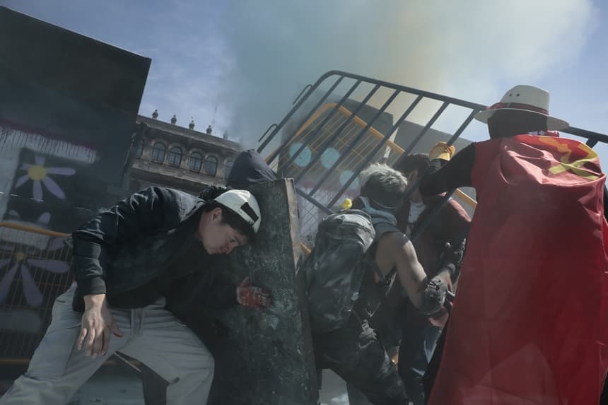 Manifestantes derriban vallas en una protesta este sábado, en inmediaciones del Palacio Nacional en Ciudad de México (EFE/ José Méndez)