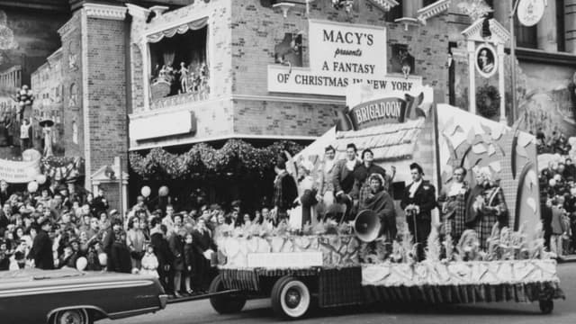 Carroza del City Center Light Opera, producción del musical «Brigadoon», durante el Desfile del Día de Acción de Gracias de Macy's en Nueva York, el 26 de noviembre de 1961. El letrero detrás dice: «Macy's presenta una fantasía navideña en Nueva York». (Foto de Archive Photos/Getty Images)