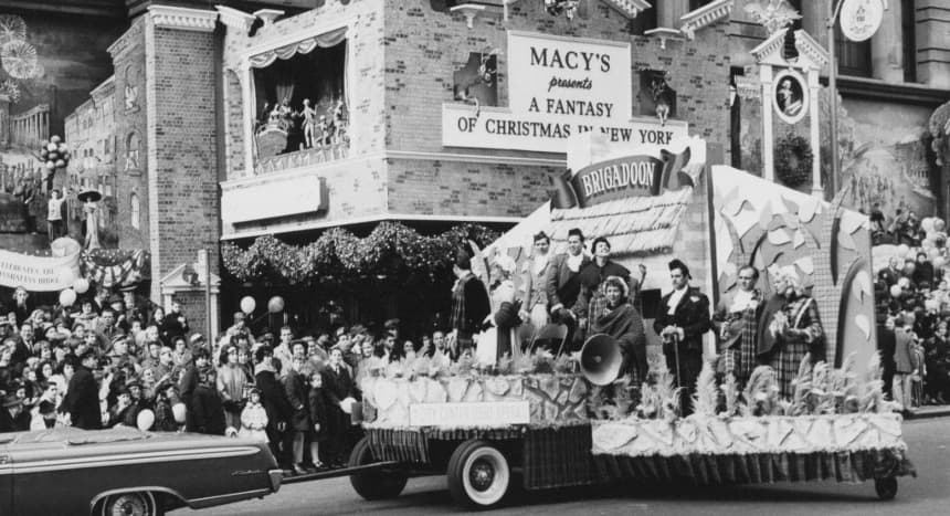 Carroza del City Center Light Opera, producción del musical «Brigadoon», durante el Desfile del Día de Acción de Gracias de Macy's en Nueva York, el 26 de noviembre de 1961. El letrero detrás dice: «Macy's presenta una fantasía navideña en Nueva York». (Foto de Archive Photos/Getty Images)