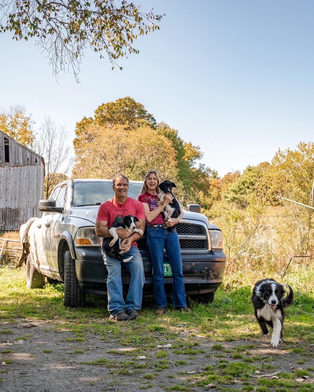 El agricultor y abogado John Klar y su esposa Jacqui Klar sostienen a sus cachorros Ash y Sampson en su granja en Brookfield, Vermont, el 12 de septiembre de 2025. (Samira Bouaou/The Epoch Times)