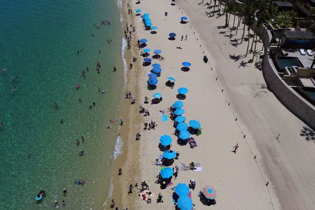 Vista aérea de turistas disfrutando de la playa en un complejo turístico en Los Cabos, Baja California, México, el 15 de julio de 2025. (ALFREDO ESTRELLA/AFP vía Getty Images)