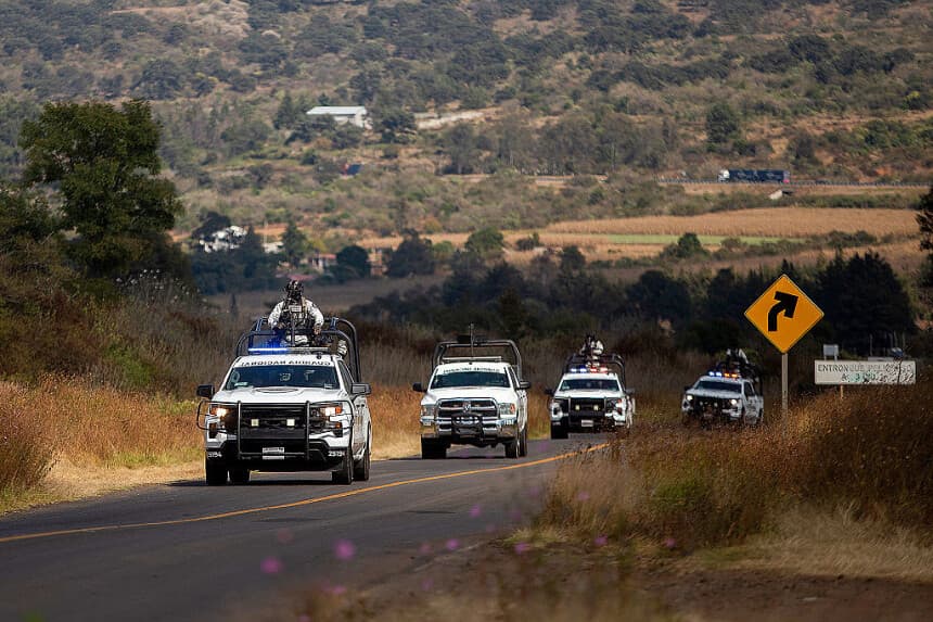 Agentes de la Guardia Nacional de México patrullan la zona donde cuatro vehículos fueron incendiados por presuntos miembros del crimen organizado en una carretera cerca de Quiroga, estado de Michoacán, México, el 17 de noviembre de 2025. Civiles armados bloquearon varias carreteras en el estado occidental mexicano de Michoacán el 17 de noviembre de 2025, en respuesta a una operación contra un líder criminal, una semana después de que el gobierno de la presidenta Claudia Sheinbaum reforzara la presencia de las fuerzas federales en el estado. (ENRIQUE CASTRO/AFP vía Getty Images)