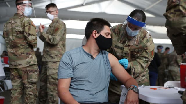 Un soldado del Ejército de los Estados Unidos vacuna a Max Pietro con la vacuna contra COVID-19 de Johnson & Johnson en el campus norte del Miami Dade College el 10 de marzo de 2021 en North Miami, Florida. (Foto de Joe Raedle/Getty Images)