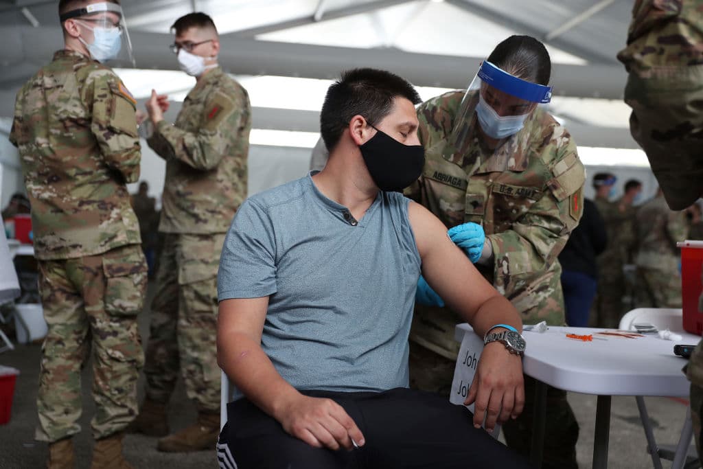 Un soldado del Ejército de los Estados Unidos vacuna a Max Pietro con la vacuna contra COVID-19 de Johnson & Johnson en el campus norte del Miami Dade College el 10 de marzo de 2021 en North Miami, Florida. (Foto de Joe Raedle/Getty Images)