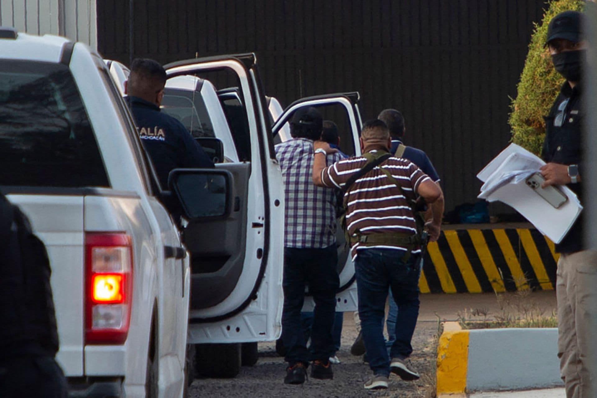 Agentes de la Fiscalía General de Michoacán escoltan a siete policías municipales detenidos tras el asesinato del alcalde Carlos Manzo en Uruapan, estado de Michoacán, México, el 21 de noviembre de 2025. (ENRIQUE CASTRO / AFP vía Getty Images)