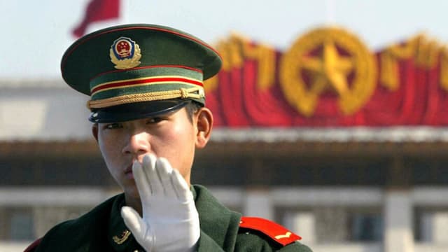 Un policía paramilitar gesticula mientras patrulla en la plaza de Tiananmen, en Beijing, el 13 de noviembre de 2002. (FREDERIC BROWN/AFP vía Getty Images)