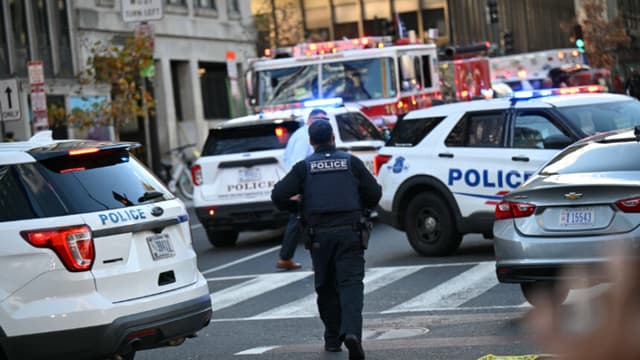 Un agente de la Policía Metropolitana camina entre coches patrulla cerca de la escena del crimen tras un tiroteo en el centro de Washington D. C., el 26 de noviembre de 2025. Dos miembros de la Guardia Nacional fueron tiroteados el miércoles a pocas manzanas de la Casa Blanca, según informaron las autoridades, mientras que un portavoz de Donald Trump afirmó que el presidente había sido informado de la "trágica situación". La policía afirmó haber detenido a un sospechoso. (Foto de Drew ANGERER / AFP a través de Getty Images).