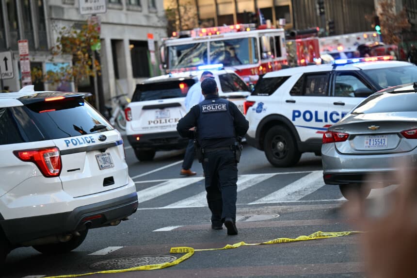 Un agente de la Policía Metropolitana camina entre coches patrulla cerca de la escena del crimen tras un tiroteo en el centro de Washington D. C., el 26 de noviembre de 2025. Dos miembros de la Guardia Nacional fueron tiroteados el miércoles a pocas manzanas de la Casa Blanca, según informaron las autoridades, mientras que un portavoz de Donald Trump afirmó que el presidente había sido informado de la "trágica situación". La policía afirmó haber detenido a un sospechoso. (Foto de Drew ANGERER / AFP a través de Getty Images).