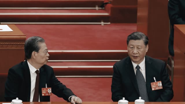 El presidente chino, Xi Jinping, habla con el presidente de la Asamblea Popular Nacional, Zhao Leji, durante la quinta sesión plenaria de la Asamblea Popular Nacional, celebrada el 12 de marzo de 2023 en Beijing, China. (Lintao Zhang/Getty Images)