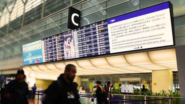 Un tablón de anuncios en la sala de facturación de All Nippon Airways (ANA) muestra un aviso de que era necesaria una actualización de software para los aviones Airbus A321/A320 de la aerolínea, lo que provocaría retrasos y cancelaciones de vuelos, en el aeropuerto de Haneda, en Tokio, el 29 de noviembre de 2025. Varias aerolíneas anunciaron retrasos o cancelaciones de vuelos tras una alerta de Airbus de que hasta 6000 aviones de la familia A320 en servicio podrían necesitar actualizaciones. (Kazuhiro NOGI / AFP a través de Getty Images)