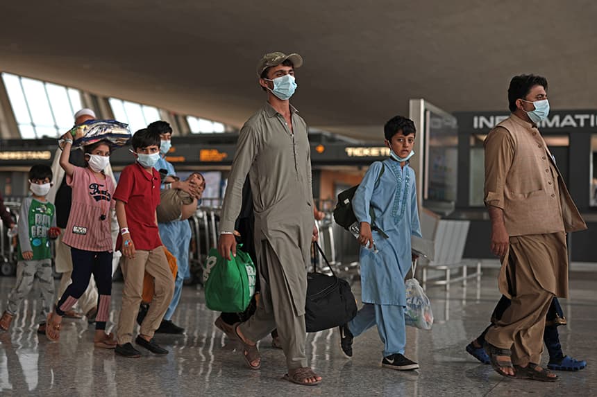 Refugiados caminan por la terminal de salidas hacia un autobús en el Aeropuerto Internacional de Dulles tras ser evacuados de Kabul tras la toma del poder por los talibanes en Afganistán el 31 de agosto de 2021 en Dulles, Virginia. (Anna Moneymaker/Getty Images)