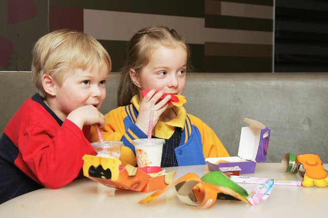 MELBOURNE, AUSTRALIA - 29 DE AGOSTO: Niños comiendo un nuevo Happy Meal en el restaurante McDonald's de Collingwood el 29 de agosto de 2006 en Melbourne, Australia. El nuevo Happy Meal es una alternativa baja en grasas al Happy Meal tradicional de la cadena de comida rápida. La obesidad infantil es un grave problema de salud en Australia y se ha triplicado en los últimos 20 años, hasta el punto de que uno de cada seis niños australianos está clasificado como obeso. (Foto de Kristian Dowling/Getty Images).