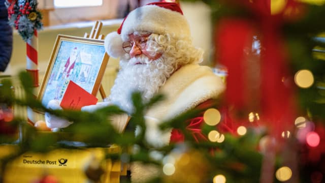 Un hombre vestido de Papá Noel habla con los niños y lee sus cartas durante la inauguración de la tradicional oficina de correos de Papá Noel en el pueblo de Himmelpfort, al noreste de Alemania, el 13 de noviembre de 2026. (Foto de Odd ANDERSEN / AFP) (Foto de ODD ANDERSEN/AFP vía Getty Images).