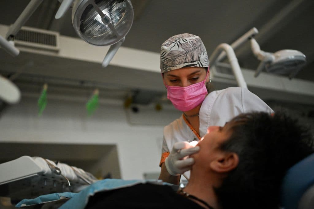 Ornella Sol Fritzler, estudiante de odontología, examina a un paciente en Buenos Aires el 18 de septiembre de 2024. (Foto de LUIS ROBAYO / AFP) (Foto de LUIS ROBAYO/AFP a través de Getty Images)