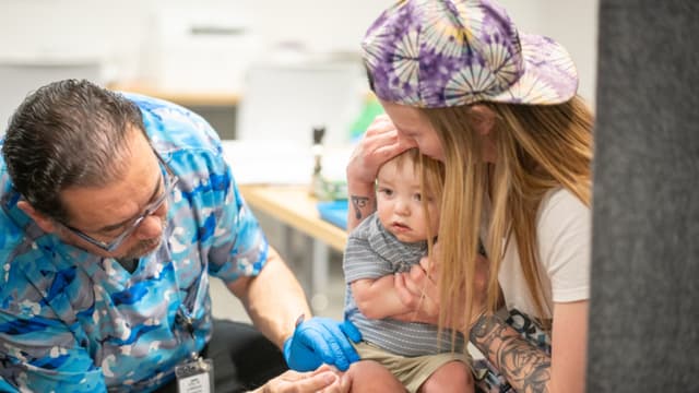 River Jacobs, de un año, es sostenido por su madre, Caitlin Fuller, mientras recibe una vacuna MMR de Raynard Covarrubio, en una clínica de vacunación organizada por el Departamento de Salud Pública de Lubbock el 1 de marzo de 2025 en Lubbock, Texas. (Jan Sonnenmair/Getty Images)