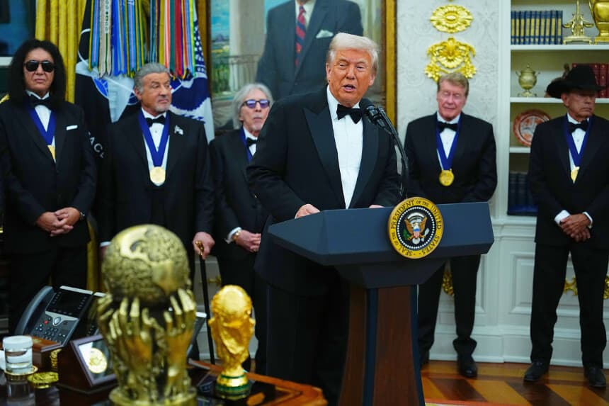 El presidente de los Estados Unidos, Donald Trump, pronuncia unas palabras mientras los galardonados (de izquierda a derecha) el músico Gene Simmons, de la banda de rock KISS, el actor Sylvester Stallone, el músico Peter Criss, de la banda de rock KISS, el actor Michael Crawford y el músico country George Strait observan durante la ceremonia de entrega de medallas a los galardonados del Kennedy Center 2025 en el Despacho Oval de la Casa Blanca el 6 de diciembre de 2025 en Washington, D.C.(AAaron Schwartz/Getty Images)