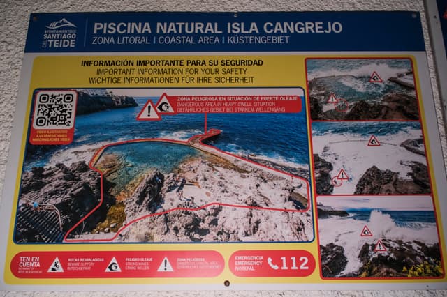 Imagen tomada este domingo del cartel que informa de los peligros con oleaje de la piscina natural de Isla Cangrejo, en Los Gigantes (Tenerife), donde cuatro personas fallecieron esta tarde al ser arrastradas por un golpe de mar. (EFE/Alberto Valdés)