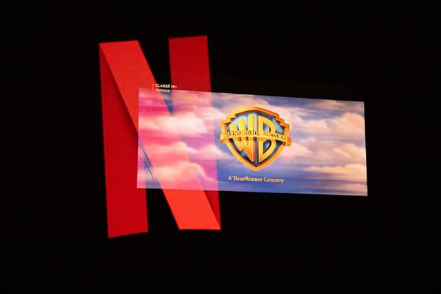 Fotografía de doble exposición del logotipo de Netflix y el logotipo de Warner Bros en una pantalla de televisión en Kerlouan, Bretaña, Francia, el 5 de diciembre de 2025. (Vincent Feuray / Hans Lucas / AFP vía Getty Images)