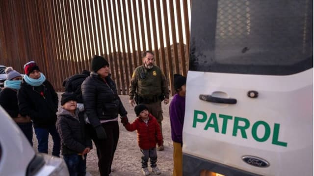 Agentes de la Patrulla Fronteriza de EE. UU. vigilan a los inmigrantes junto a la valla fronteriza entre EE. UU. y México antes de trasladarlos para su tramitación el 19 de enero de 2025 cerca de Sasabe, Arizona. (John Moore/Getty Images)