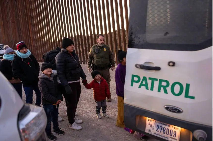 Agentes de la Patrulla Fronteriza de EE. UU. vigilan a los inmigrantes junto a la valla fronteriza entre EE. UU. y México antes de trasladarlos para su tramitación el 19 de enero de 2025 cerca de Sasabe, Arizona. (John Moore/Getty Images)