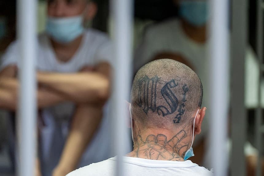 Un preso con tatuajes de la pandilla MS-13 permanece de pie en su celda mientras la secretaria del Departamento de Seguridad Nacional, Kristi Noem, visita el Centro de Confinamiento de Terroristas (CECOT) el 26 de marzo de 2025 en Tecoluca, El Salvador. (Alex Brandon-Pool/Getty Images)