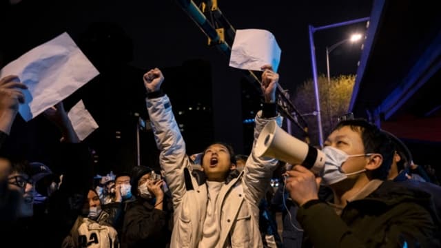 Manifestantes gritan consignas durante una protesta contra las estrictas medidas de cero COVID de China, en Beijing, China, el 28 de noviembre de 2022. (Kevin Frayer/Getty Images)