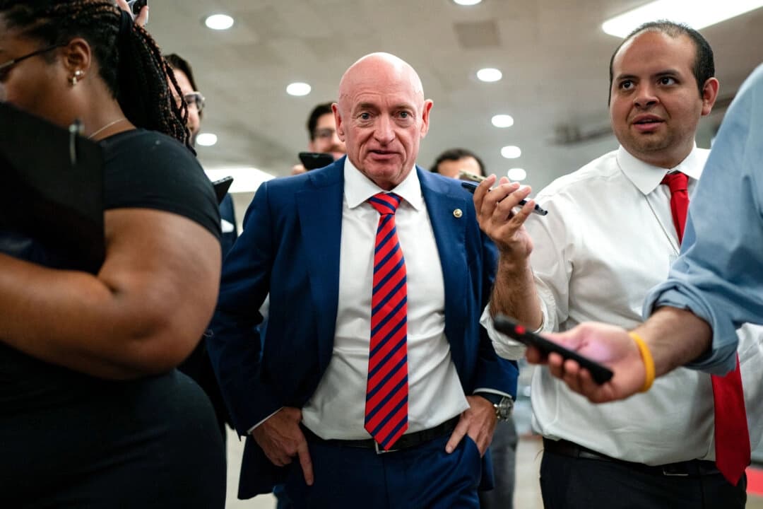El senador Mark Kelly (D-Ariz.) habla con periodistas mientras espera para tomar el metro del Senado hasta el edificio Hart desde el Capitolio de los Estados Unidos en Washington el 25 de julio de 2024. (Kent Nishimura/Getty Images)