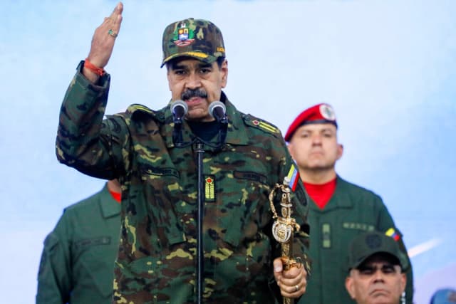 El presidente de Venezuela, Nicolás Maduro, sostiene la espada de Simón Bolívar mientras se dirige a miembros de las fuerzas armadas, la Milicia Bolivariana, la policía y civiles durante una manifestación contra una posible escalada de las acciones estadounidenses hacia el país, en la base militar de Fuerte Tiuna en Caracas, Venezuela, el 25 de noviembre de 2025. (REUTERS/Leonardo Fernández Viloria)