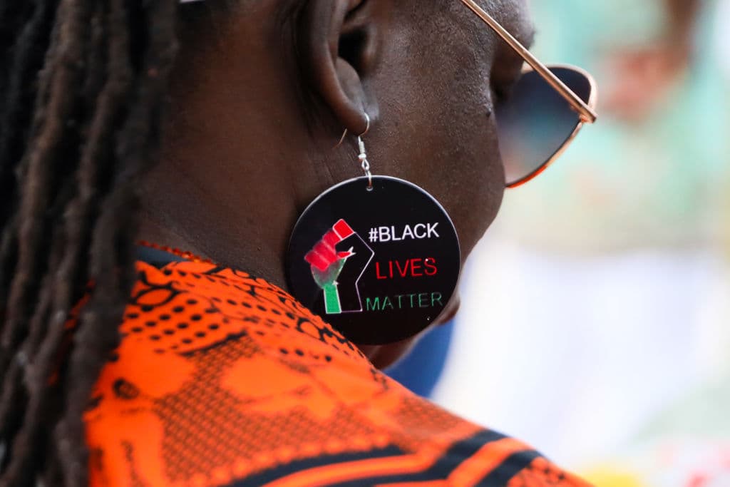 Una mujer con pendientes con el lema "Black Lives Matter" se une a la gente reunida en Windrush Square, Brixton, para celebrar el 76.º aniversario de Windrush el 23 de junio de 2024 en Londres, Inglaterra. (Foto de Alishia Abodunde/Getty Images)