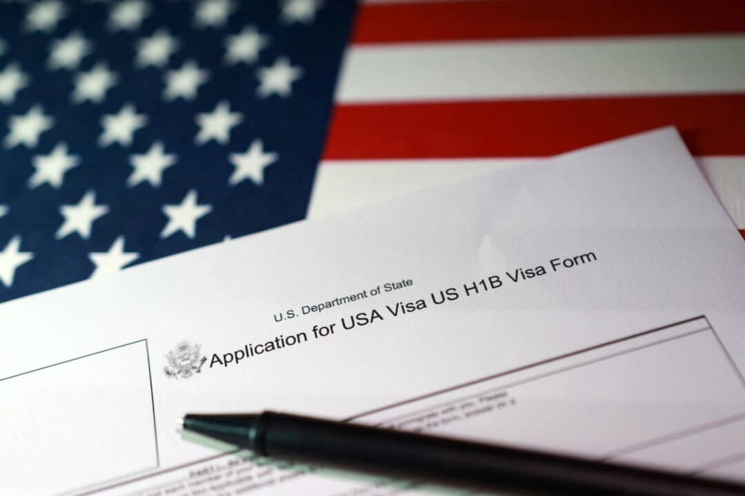 Una bandera estadounidense y un formulario de solicitud de visa H-1B, el 22 de septiembre de 2025. (Dado Ruvic/Ilustración/Reuters)