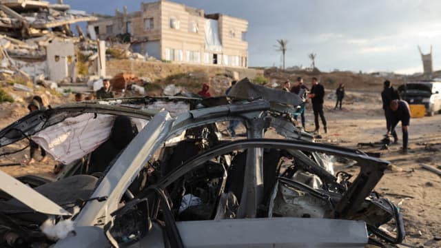 Palestinos inspeccionan el lugar de un ataque israelí contra un automóvil en la Ciudad de Gaza, el 13 de diciembre de 2025. (Omar AL-QATTAA / AFP via Getty Images)