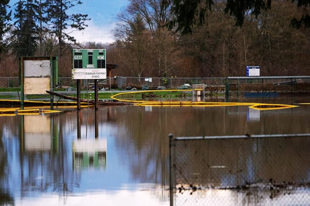 Las aguas de la crecida del río Skagit cubren un campo de juego en el parque Riverfront de Sedro-Woolley, Washington, el 12 de diciembre de 2025. Decenas de miles de personas recibieron órdenes de evacuación el 11 de diciembre en el oeste de Norteamérica, después de que varios días de fuertes lluvias provocaran el desbordamiento de los ríos. Las tormentas han azotado durante varios días el estado de Washington, en Estados Unidos, y la Columbia Británica, al otro lado de la frontera canadiense, y los ríos siguen creciendo. (Jason Redmond / AFP vía Getty Images)