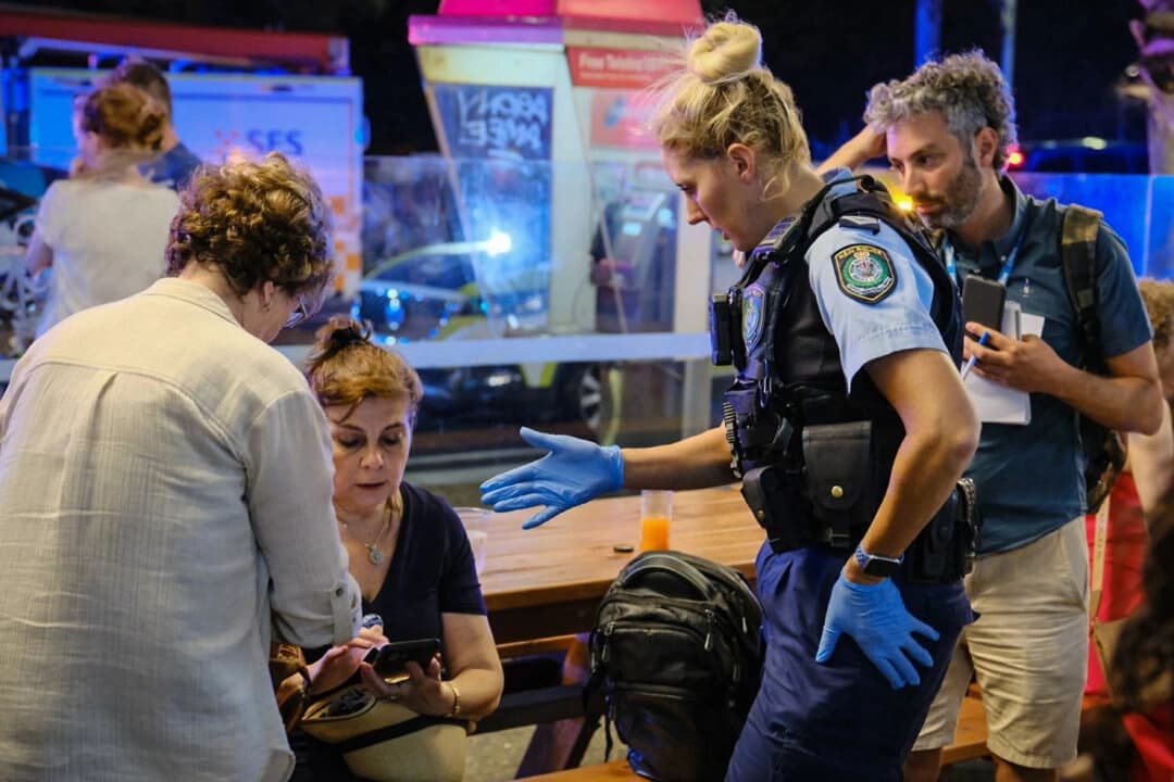 Los servicios de emergencia de la policía hablan con el público en la escena de un tiroteo masivo en Bondi Beach en Sídney, Australia, el 14 de diciembre de 2025. (George Chan/Getty Images)
