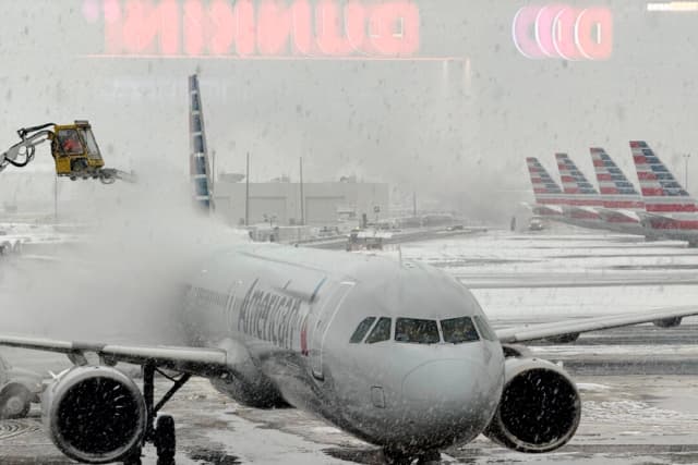 Un avión de American Airlines recibe un tratamiento de deshielo antes de su salida en el Aeropuerto Internacional Newark Liberty, en Newark, Nueva Jersey, el 14 de diciembre de 2025. (T.J. Muscaro/The Epoch Times).