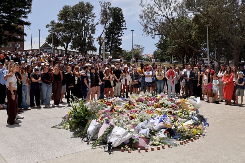 Los dolientes se reúnen con ofrendas florales en el Bondi Pavillion en memoria de las víctimas del tiroteo en Bondi Beach, Sídney, el 15 de diciembre de 2025. Un padre y su hijo, armados con armas largas, dispararon y mataron a 15 personas, incluida una niña de 10 años, en Bondi Beach, Sídney, el 14 de diciembre. Las autoridades lo calificaron de ataque terrorista antisemita en una festividad judía. (DAVID GRAY/AFP vía Getty Images)