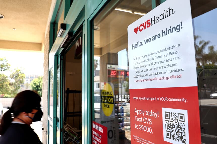 LOS ÁNGELES, CALIFORNIA - 8 DE AGOSTO: Un cartel con el mensaje "¡Hola, estamos contratando!" frente a una tienda CVS el 8 de agosto de 2022 en Los Ángeles, California. Según los informes, CVS Health Corp. tiene previsto presentar una oferta por la plataforma sanitaria Signify Health Inc., ya que CVS pretende ampliar sus servicios de atención médica a domicilio. (Foto de Mario Tama/Getty Images).
