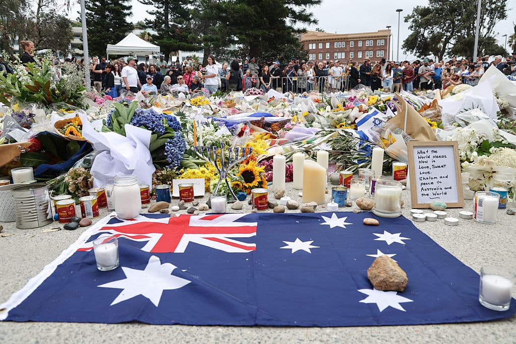 La bandera de Australia junto a las ofrendas florales frente al Bondi Pavilion en Sídney el 16 de diciembre de 2025, en honor a las víctimas del tiroteo de Bondi Beach. (Foto de DAVID GRAY / AFP a través de Getty Images)